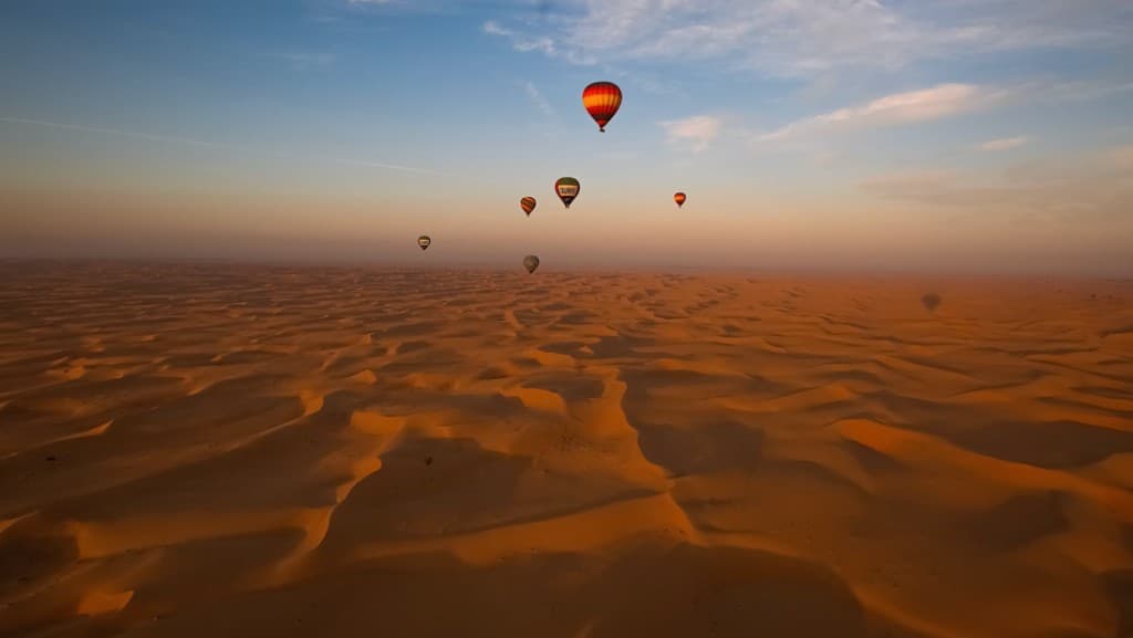 Hot air balloons over Dubai desert at sunrise